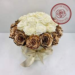 White and gold roses arranged in a round box with a ribbon