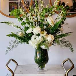 White floral arrangement in a dark glass vase