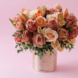 Pink and peach roses arranged in a metallic vase