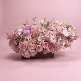 Pink and white rose arrangement in a low rectangular container