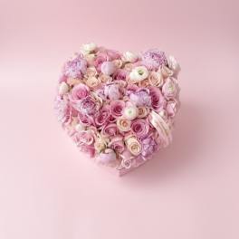 Heart-shaped bouquet of pink and white roses on a pink background