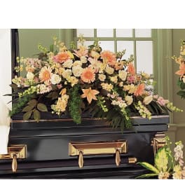 Large pastel floral spray on a black casket