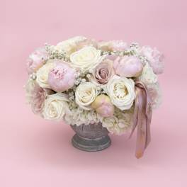 Pink and white rose bouquet in a gray pedestal vase