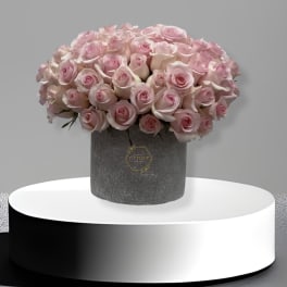 Bouquet of pale pink roses in a gray hatbox