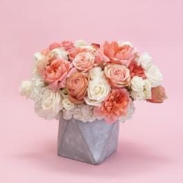 Peach and white rose arrangement in a gray geometric vase