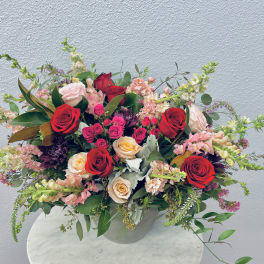 Mixed bouquet of red and blush roses in a clear vase