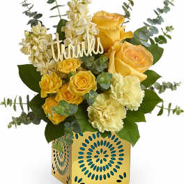 Yellow roses and carnations with a thanks pick in a yellow patterned cube vase