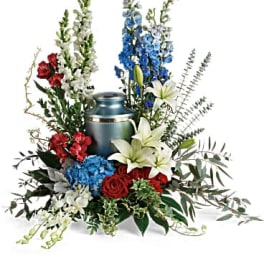 Sympathy floral arrangement with urn and mixed red, white, and blue flowers