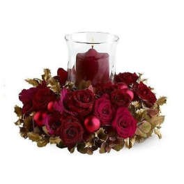 Low red rose centerpiece with gold accents and a red candle in a glass hurricane