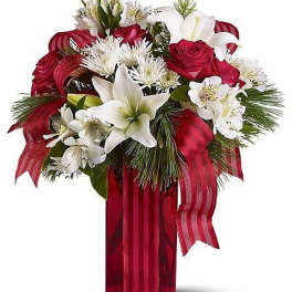 Tall red vase arrangement with red roses, white lilies, white mums, pine, and a red striped ribbon