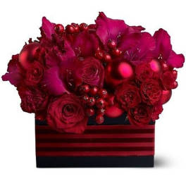 Low red arrangement of roses and orchids with red ornaments in a black striped box