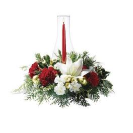 Red and white holiday centerpiece with a red taper candle in a glass chimney and evergreens
