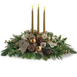 Long evergreen centerpiece with white flowers, pinecones, and three tall gold taper candles.