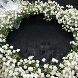 White baby's breath floral wreath with a sheer ribbon bow