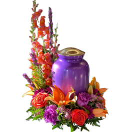 Purple urn surrounded by orange, pink, and purple flowers