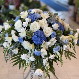 Blue and white floral arrangement in a clear vase