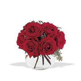 Compact arrangement of red roses in a round clear glass bowl vase