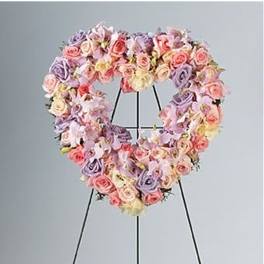 Pastel pink and lavender heart-shaped wreath of roses on a black easel stand