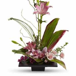 Modern pink lily and orchid arrangement with roses in a low black rectangular container
