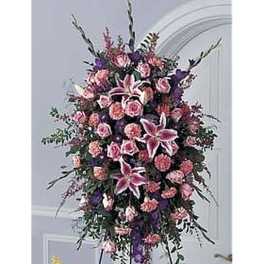 Tall pink and purple standing spray with lilies, roses, and carnations on a metal easel