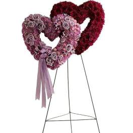 Double heart standing wreath of pink and red flowers with ribbon on a metal easel