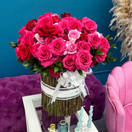 Large bouquet of pink and red roses tied with a white ribbon