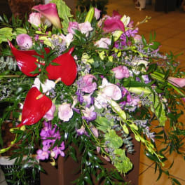 Mixed bouquet with red anthuriums, pink roses, and purple orchids