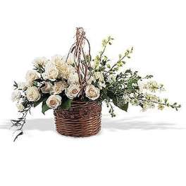 Basket arrangement of white roses and blossoms with trailing stems in an asymmetrical design