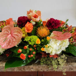 Mixed floral arrangement with pink anthuriums, orange roses, and white hydrangeas