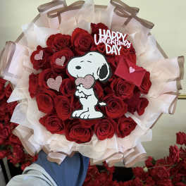 Bouquet of red roses with a Snoopy Valentine topper