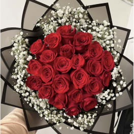 Bouquet of red roses with white baby's breath in black wrap