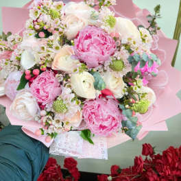 Pink and white bouquet with peonies and roses wrapped in pink paper