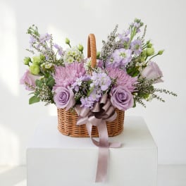 Lavender and pink flower basket with a ribbon bow