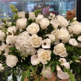 Large white rose arrangement with calla lilies and greenery