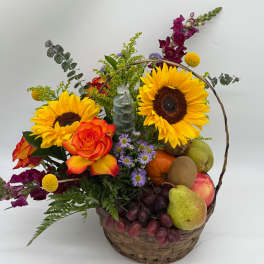 Basket arrangement with sunflowers, roses, grapes, and assorted fruit