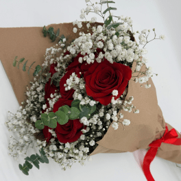 Bouquet of red roses and white baby's breath wrapped in brown paper