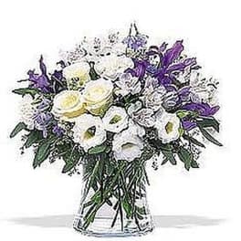 White and purple mixed flower arrangement in a clear glass vase