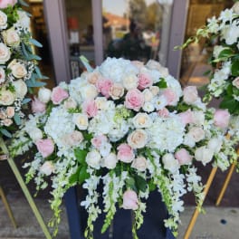 Large pastel floral arrangement with pink and white roses and cascading white blooms