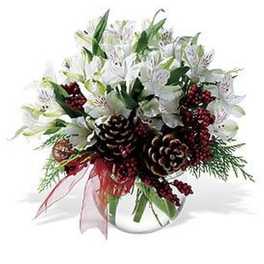 Low arrangement of white flowers with pine cones and red berries in a clear glass bowl vase.