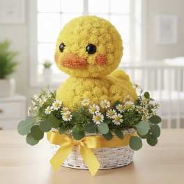Yellow duck plush in a flower basket with daisies and ribbon