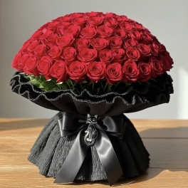 Large dome bouquet of red roses wrapped in black paper with a satin ribbon