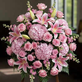 Pink roses and lilies arranged with hydrangeas in a round bouquet