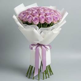 Bouquet of lavender roses wrapped in white paper with a purple ribbon