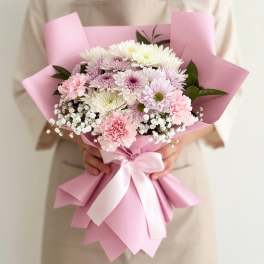 Pink-wrapped bouquet of pastel chrysanthemums with a white ribbon