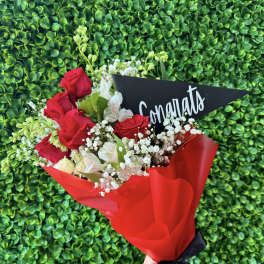 Bouquet of red roses and white flowers with a congratulatory card