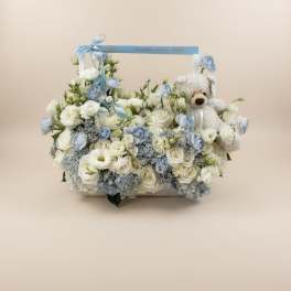 White and pale blue floral basket with a teddy bear