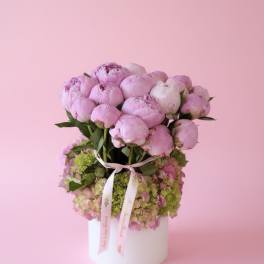 Pink peonies arranged in a white round box with a ribbon