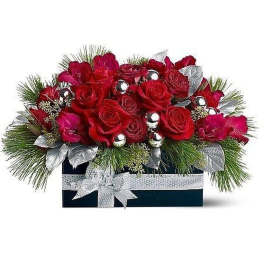 Low arrangement of red roses with pine, silver ornaments, and ribbon in a dark rectangular box