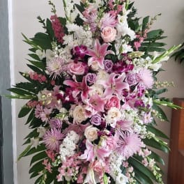 Large pink and white funeral spray on a standing easel