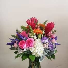 Colorful mixed bouquet in a glass vase on a decorative pedestal